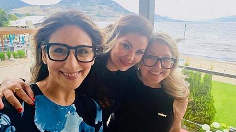 Amelia Boultbee (centre) with fellow MLAs in a scenic Okanagan waterfront setting, posted on social media just days before her announcement crossing the floor to the BC NDP caucus.