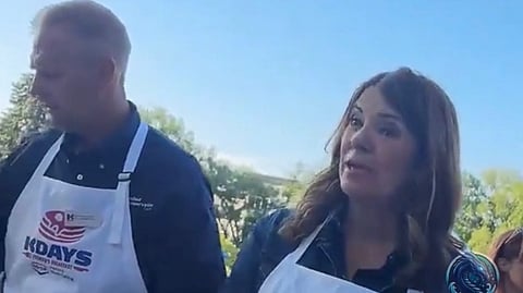 A screenshot from a video on X showing a pair of left-wing activists bombarding Premier Danielle Smith with questions about Alberta's AI data centre policies. 