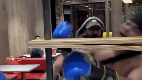 A shirtless man wearing blue boxing gloves is punched during a fight inside a McDonald’s on No. 3 Road in Richmond, B.C.