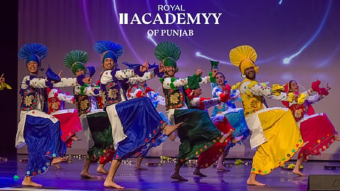 Members of the Royal Academy of Punjab perform Bhangra on stage.