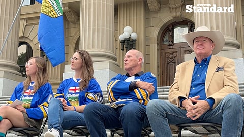 APP CEO Mitch Sylvestre, Jeffrey Rath, Madison Holmes, and Maycee Holmes sitting on the stage at the APP rally outside the Alberta Legislature Building. 