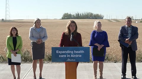 Danielle Smith speaking to reporters in Airdrie when announcing a new health centre for the community. 