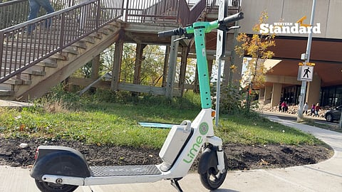 A Lime e-scooter placed in the middle of a sidewalk in Edmonton. 