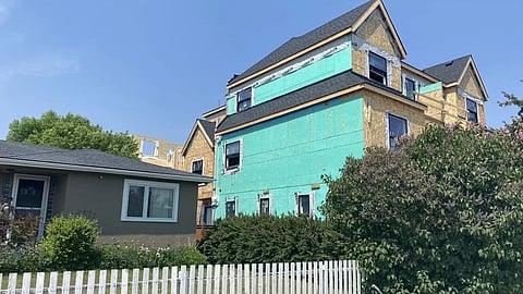 A three storey townhome project next to a single family home