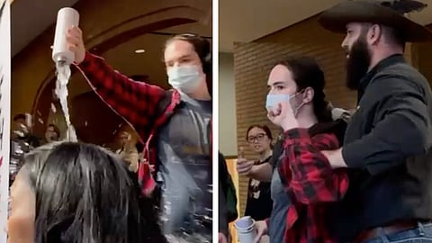 A masked individual pours water on the head of Dr. Tom Flanagan at a residential school campus discussion.
