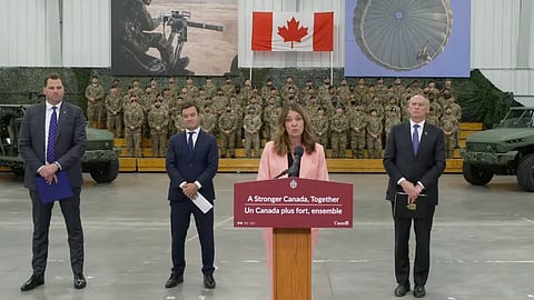 Premier Danielle Smith speaking to reporters at a national defence announcement. 