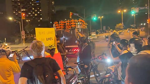 A construction truck leaves the scene after being repelled by a large protest gathering Tuesday evening
