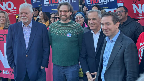 Alex MacWilliam, president of the Bridgeland-Riverside Community Association (left), Bradley Lafortune, executive director of Public Interest Alberta, Prime Minster Mark Carney and Corey Hogan, Liberal MP, in Calgary on October 15, 2026. 