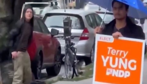 A still from a video posted September 27 shows a person on the sidewalk near supporters holding a Terry Yung campaign sign in Vancouver-Yaletown.
