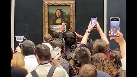 Man dressed as elderly woman throws cake at Mona Lisa painting