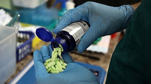 A pharmacist counts prescription drugs (source: CBC)